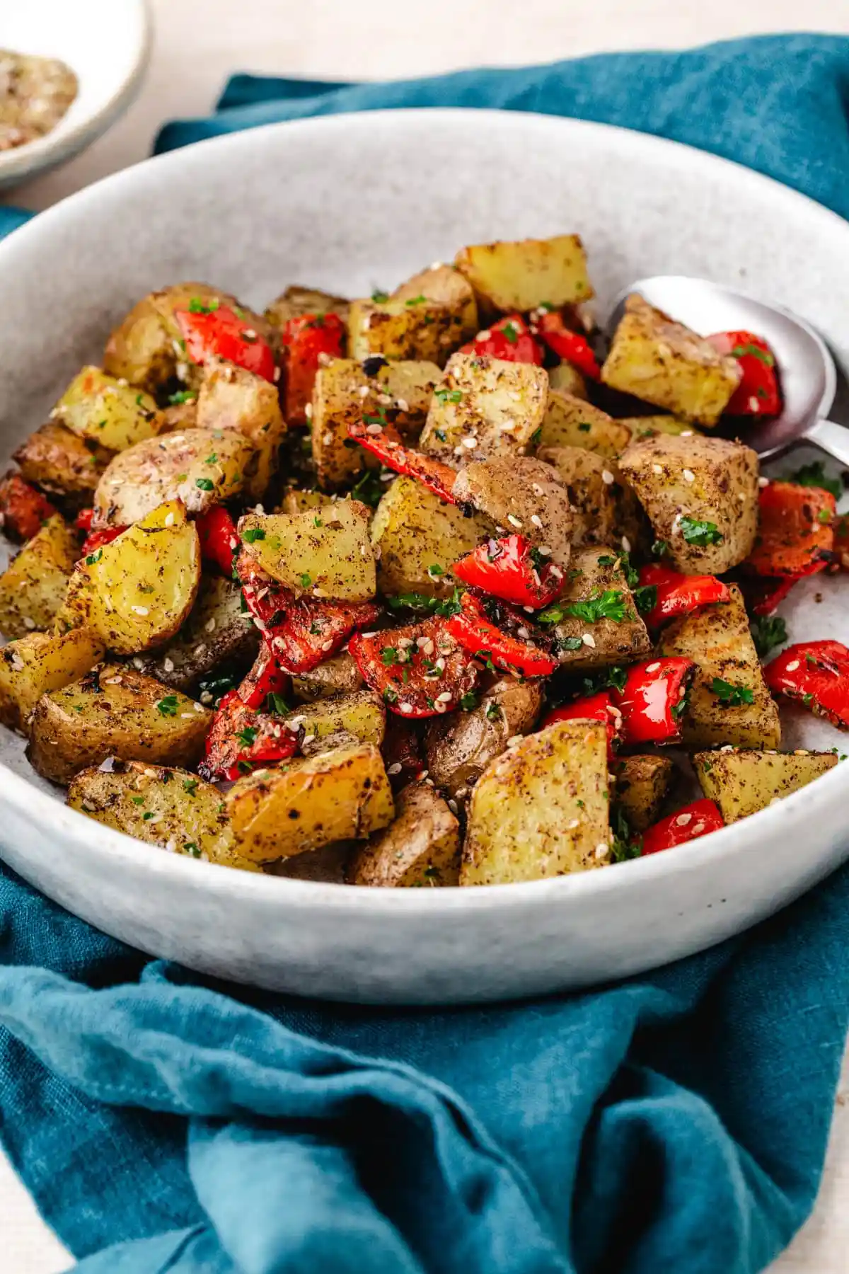 Potatoes and red peppers in white bowl